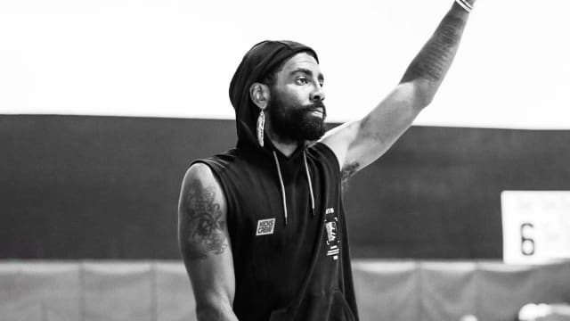 Kyrie Irving waves in a photo shoot.